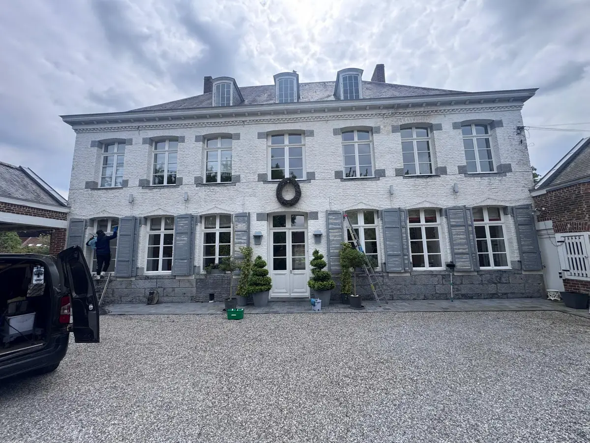 Nettoyage des vitres d'une grande maison ancienne, fourgon de l'entreprise dans la cour