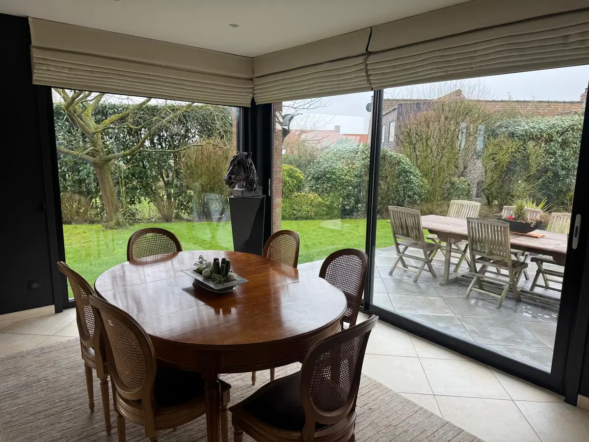 Baie vitrée d'angle propre dans une salle à manger donnant sur la terrasse
