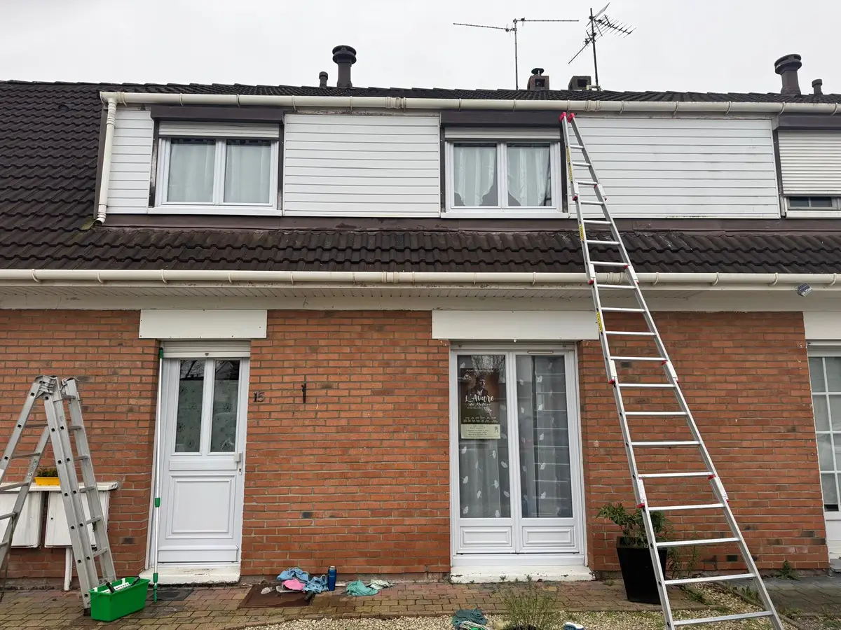 Façade en briques avec porte-fenêtres, échelle et matériel de nettoyage