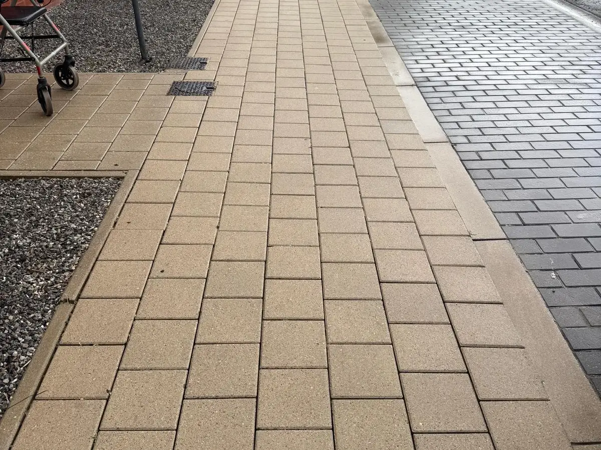 Trottoir en dalles et pavés propres le long d'une façade