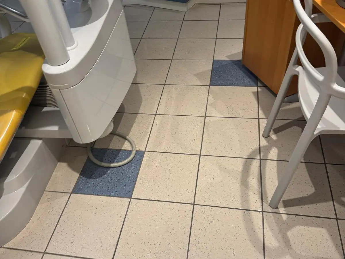 Salle de soins avec fauteuil jaune, carrelage brillant
