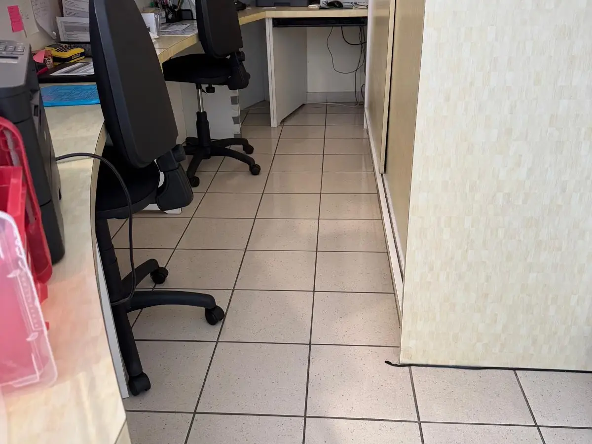 Poste d'accueil avec sièges de bureau, sol carrelé