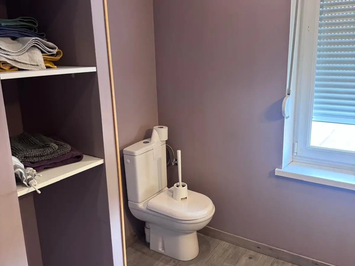 Toilettes propres dans une pièce aux murs mauves