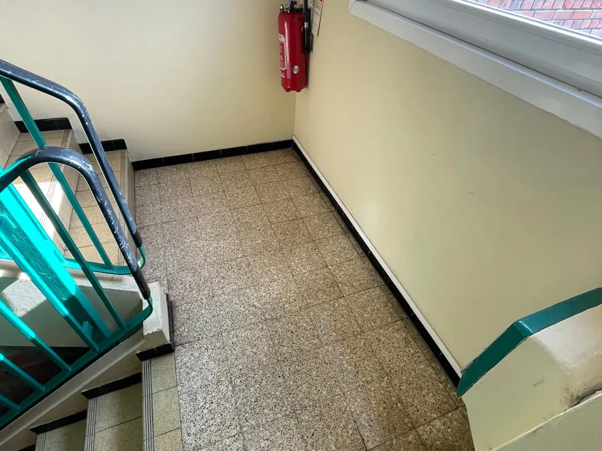 Palier d'escalier d'immeuble avec extincteur et fenêtre