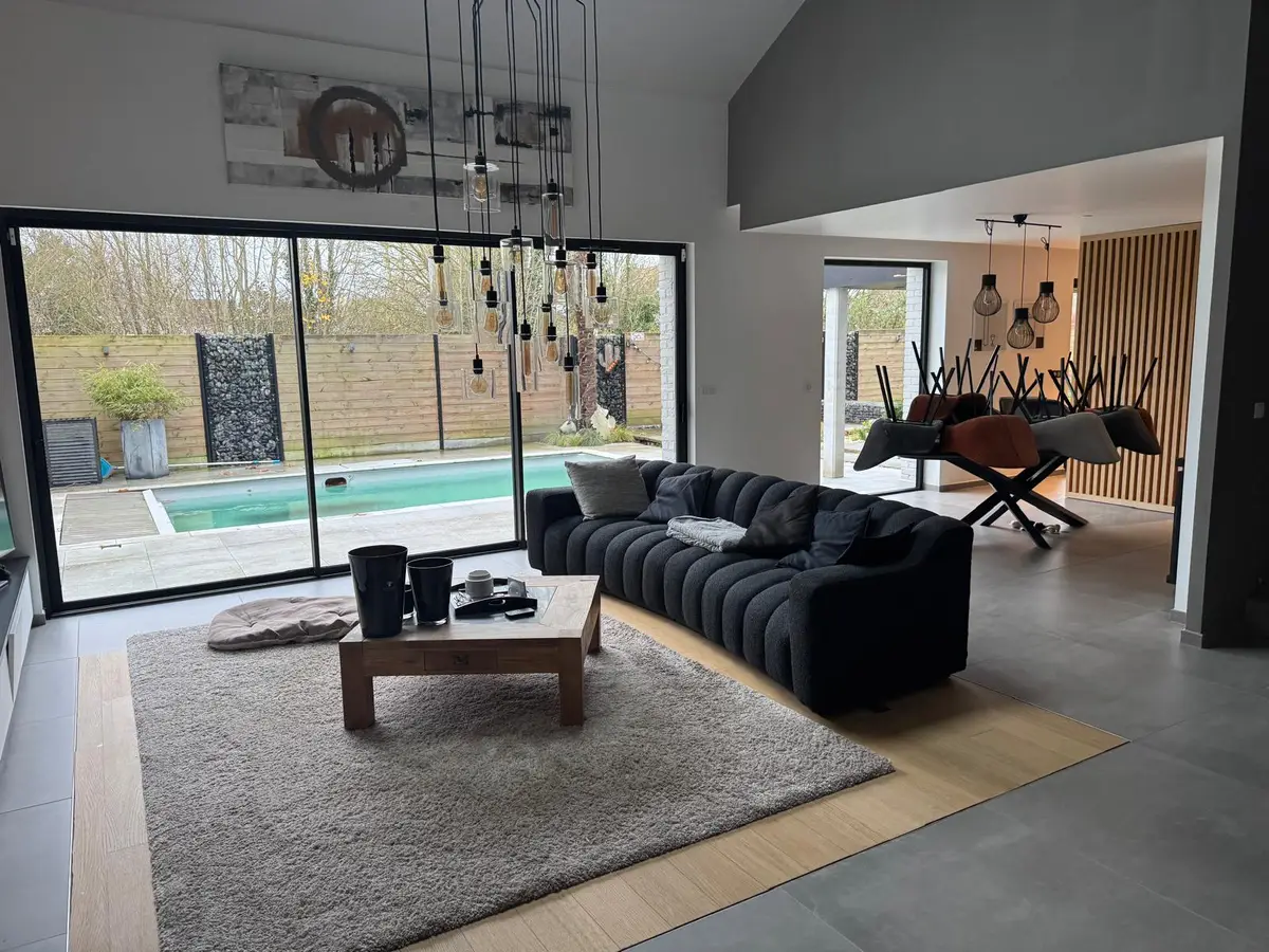 Grand salon avec baie vitrée donnant sur la piscine