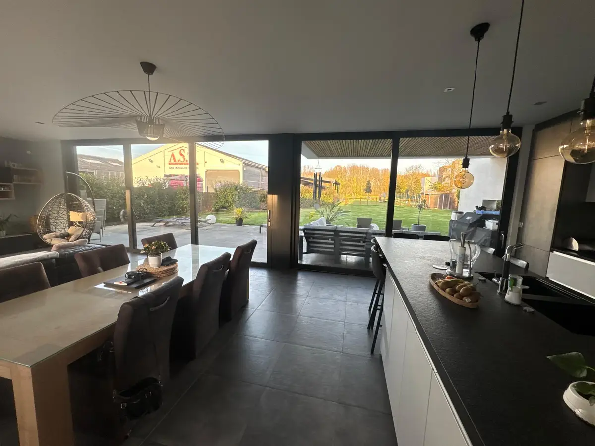 Salle à manger et cuisine ouvertes aux grandes baies vitrées