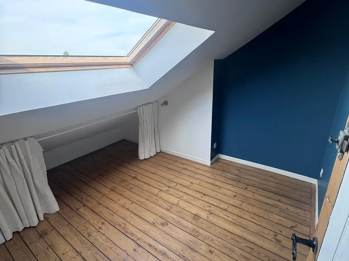 Chambre sous combles vide au parquet propre