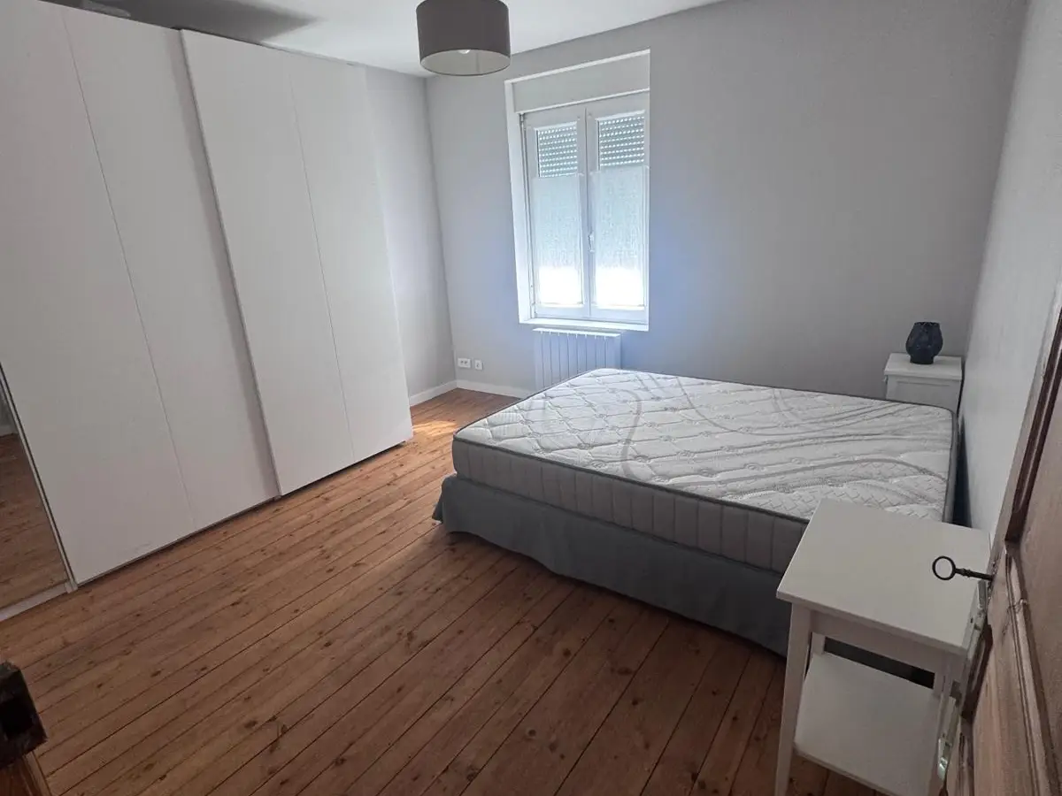 Chambre au parquet propre avec armoire blanche