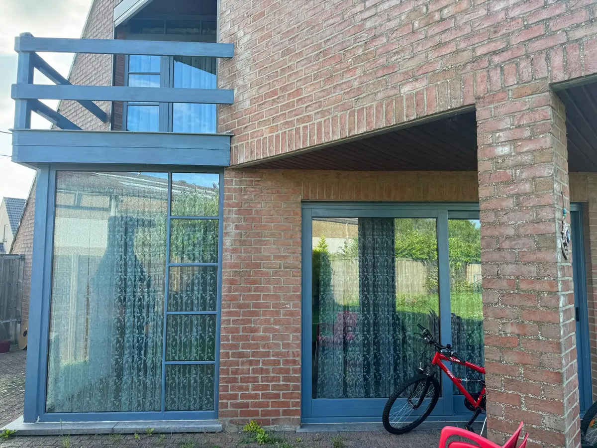 Façade en brique avec baies vitrées à cadre bleu