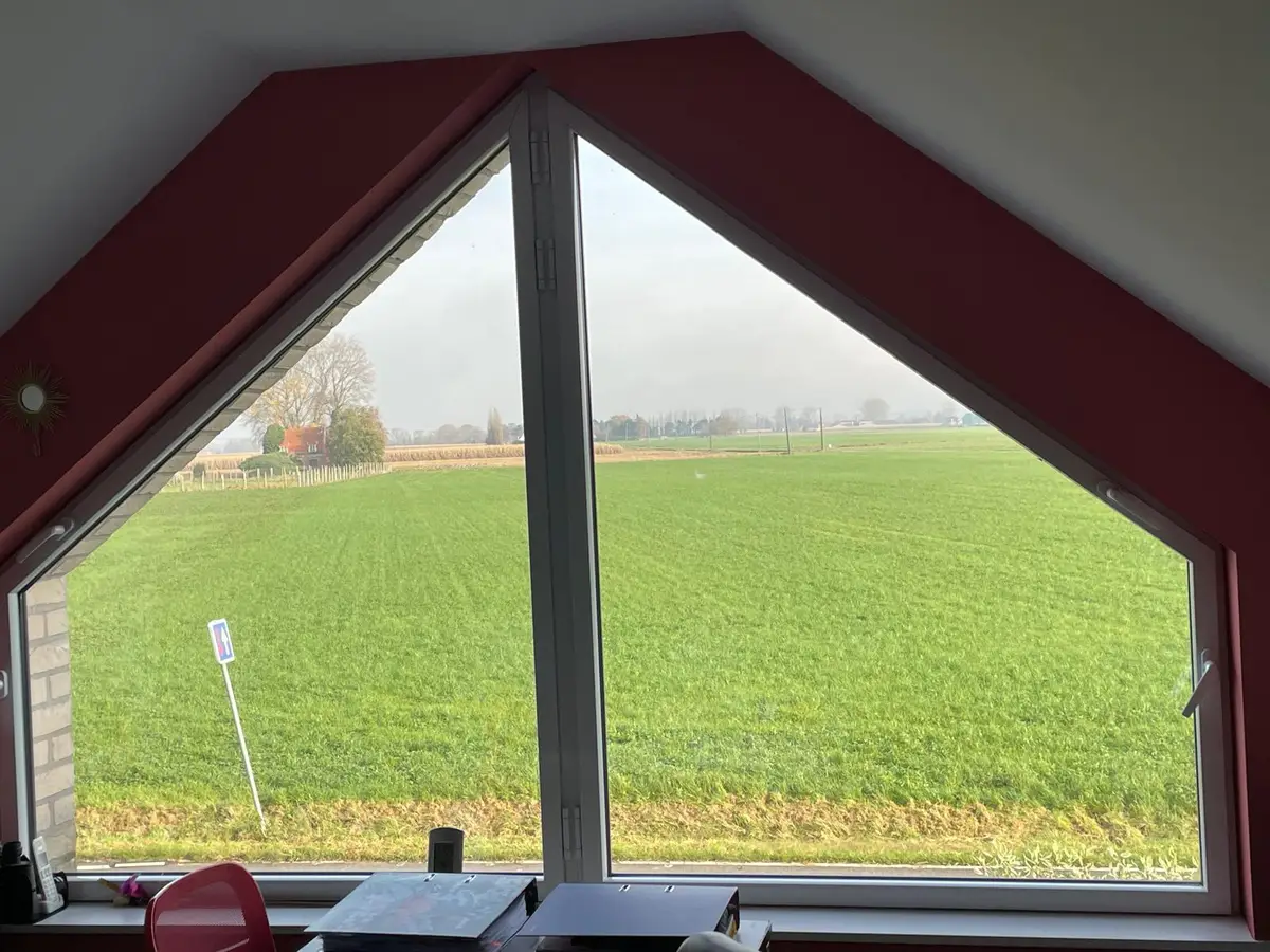 Fenêtre de pignon donnant sur un champ