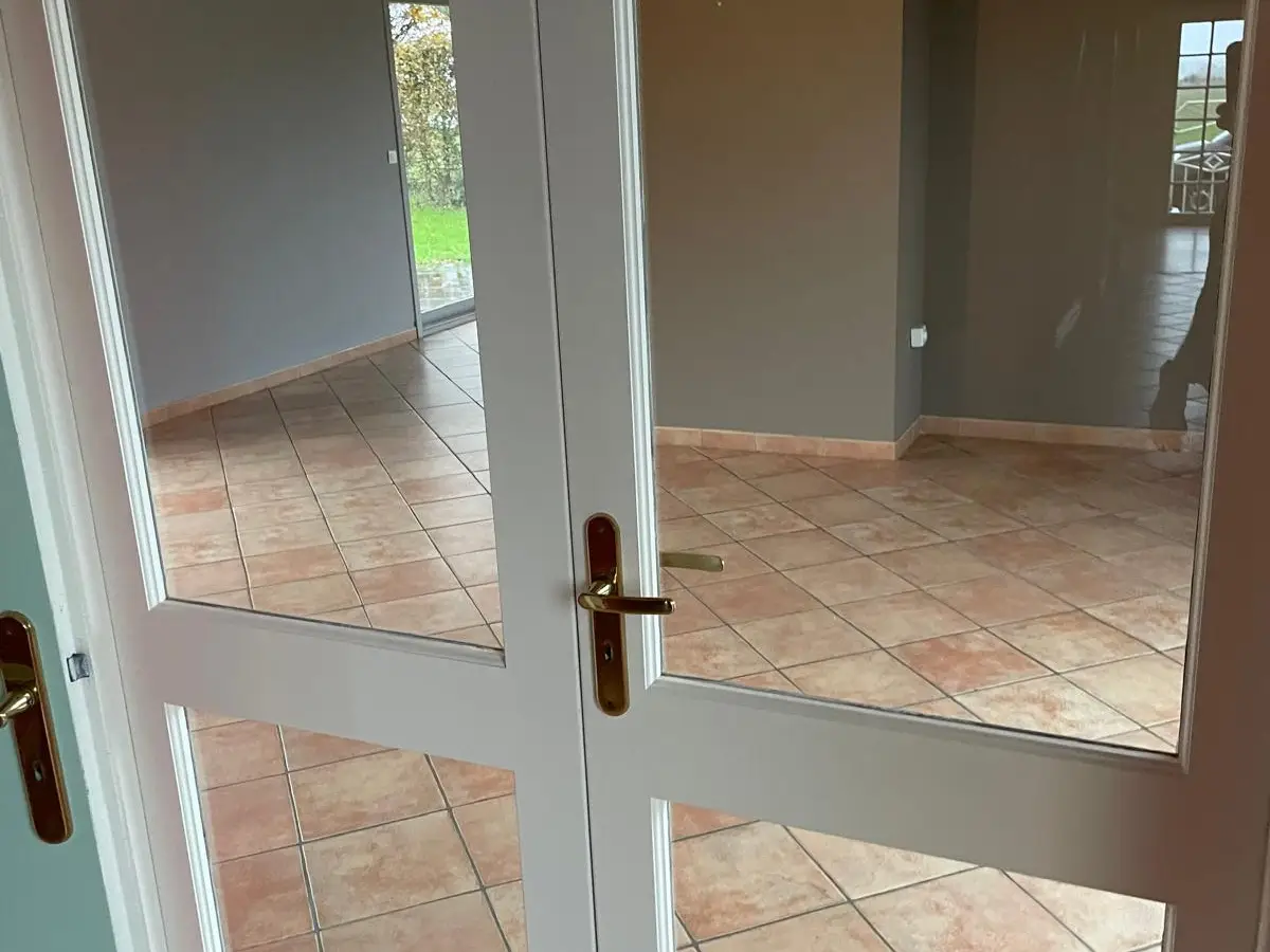 Porte-fenêtre vitrée double ouvrant sur une pièce carrelée