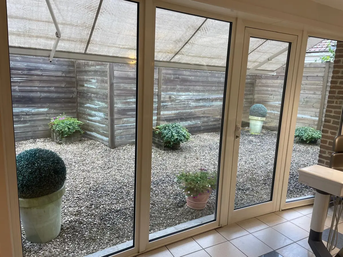Baie vitrée sur patio avec gravier et plantes