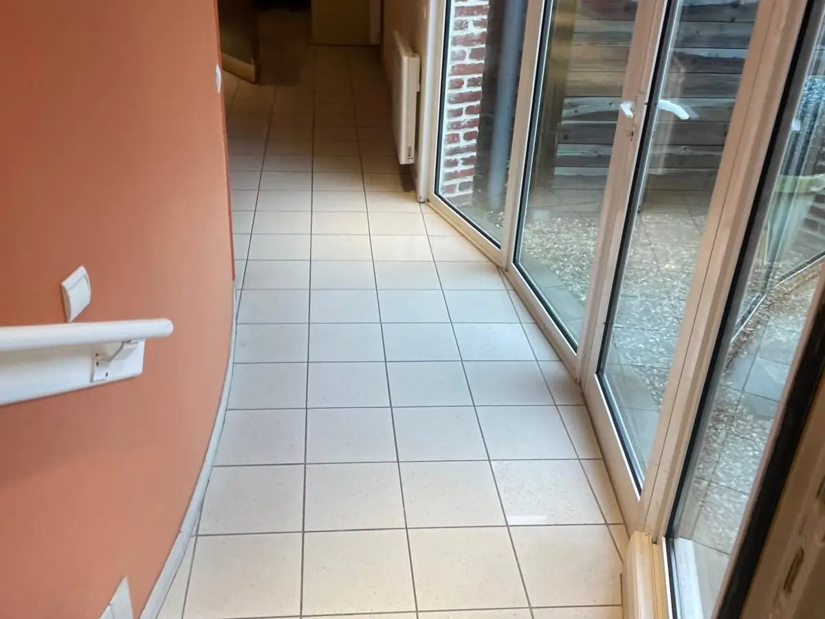Couloir le long d'une paroi vitrée courbe, carrelage propre
