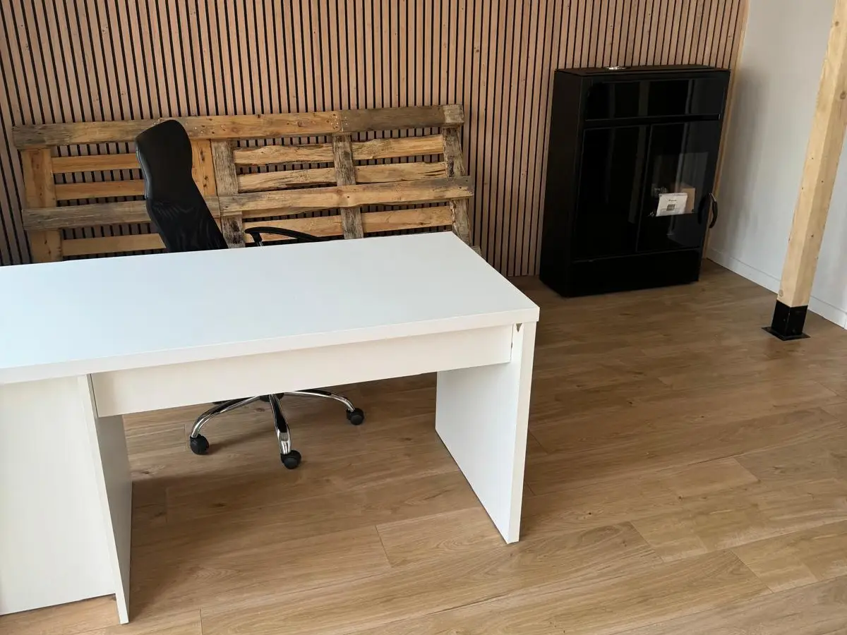 Bureau blanc devant un mur en lattes de bois