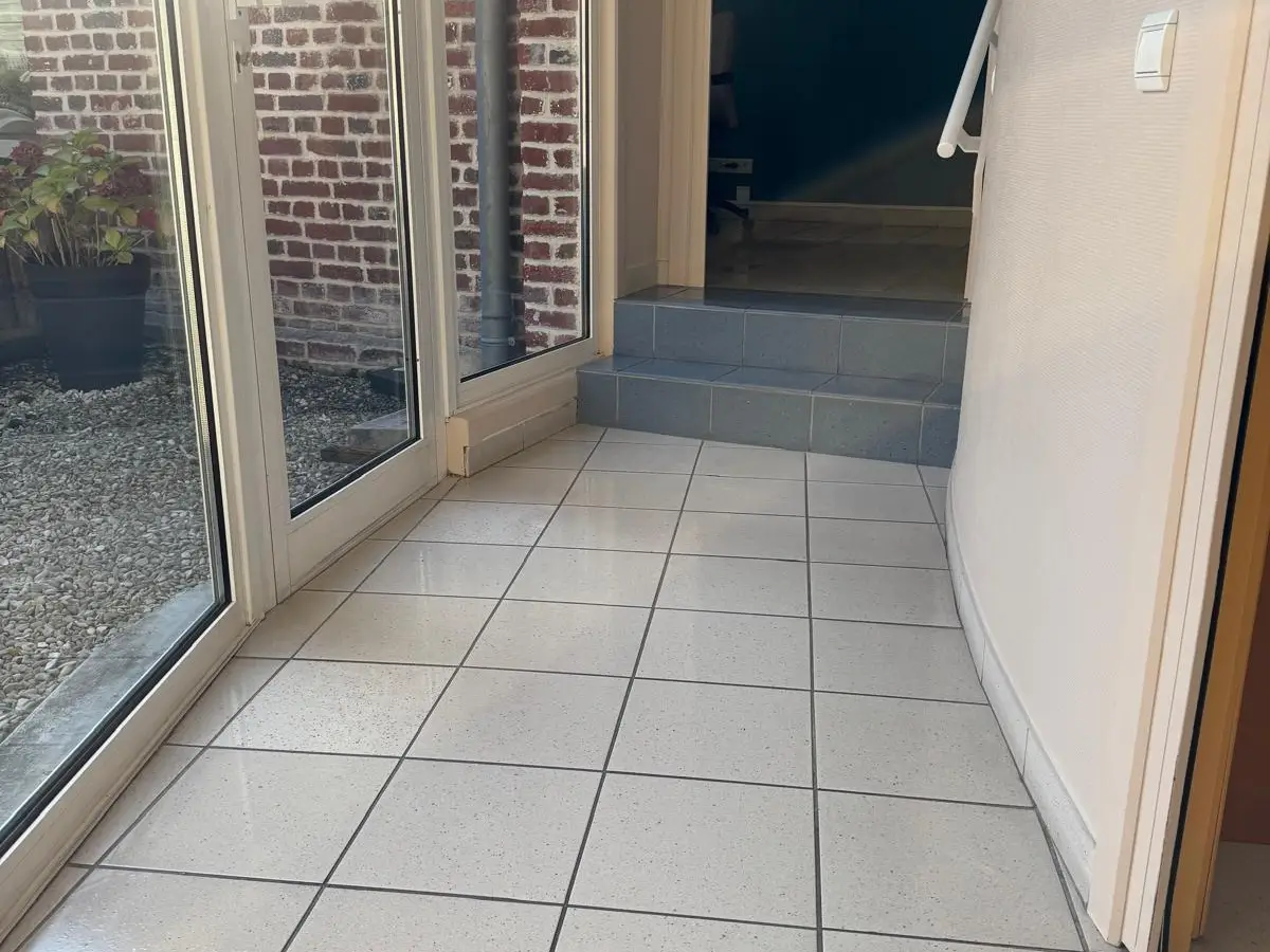 Carrelage blanc brillant le long d'une paroi vitrée