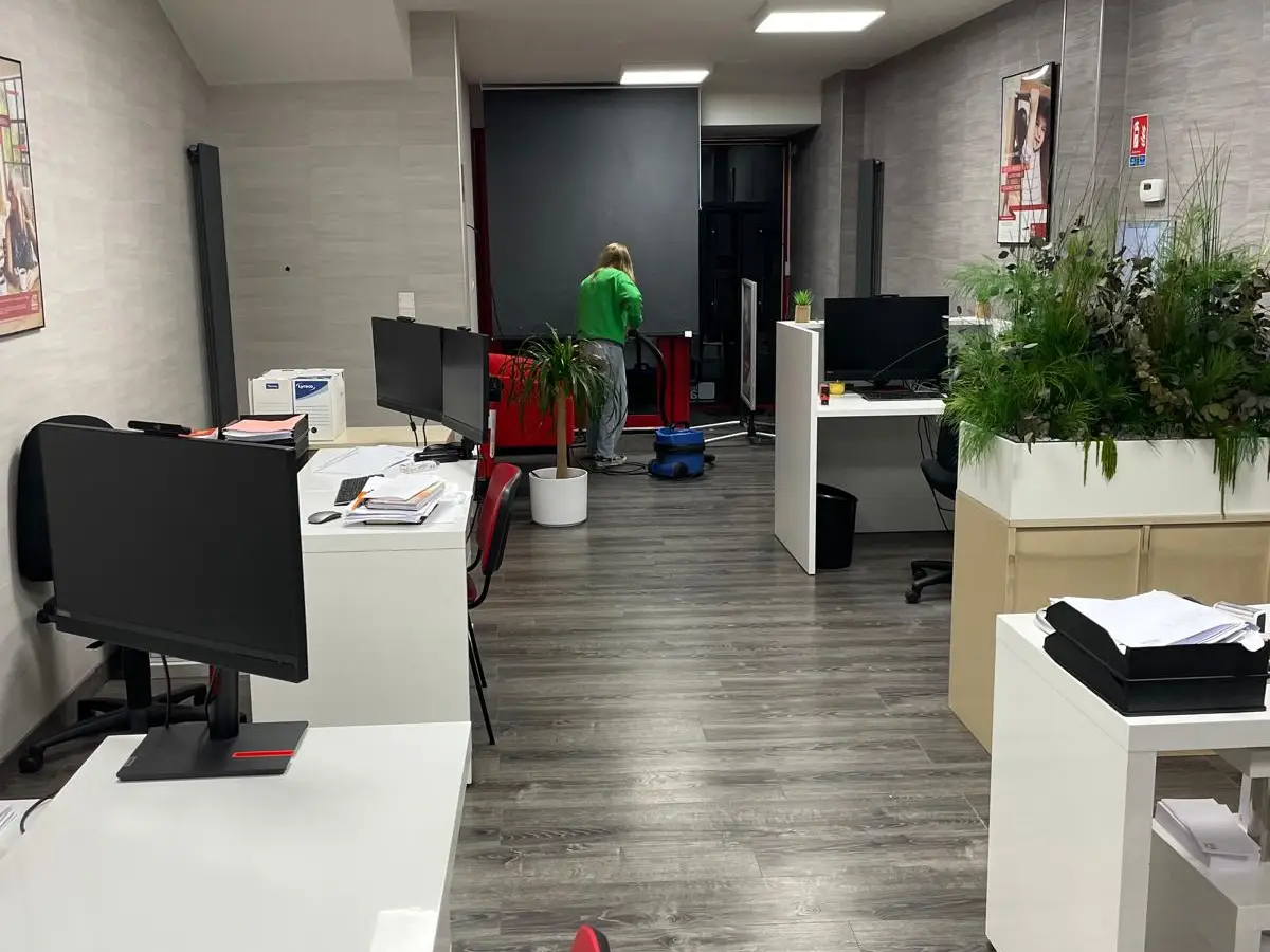 Open space avec bureaux blancs et sol gris
