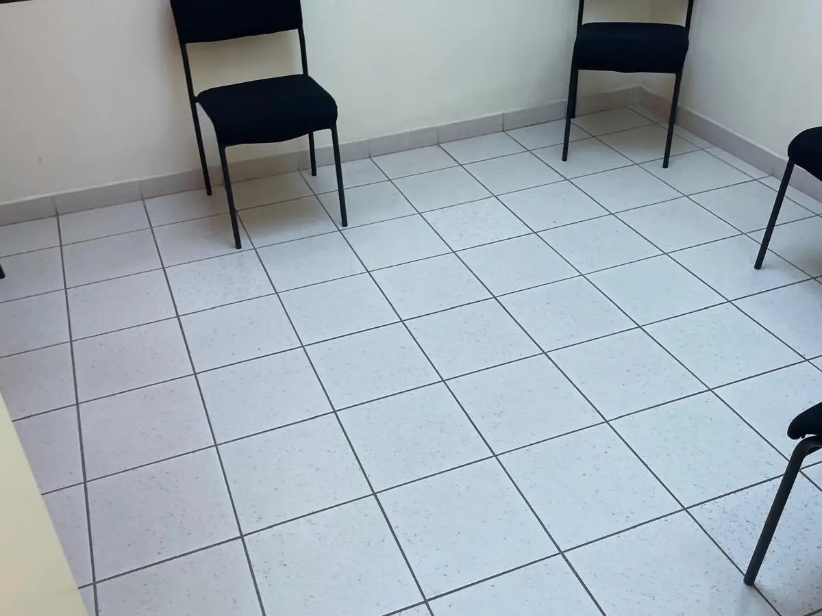 Salle d'attente carrelée avec chaises