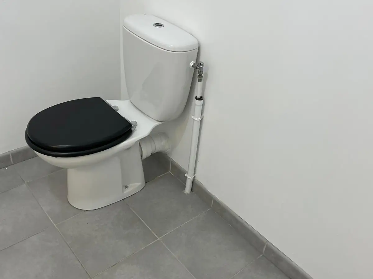 WC dans une pièce au sol gris