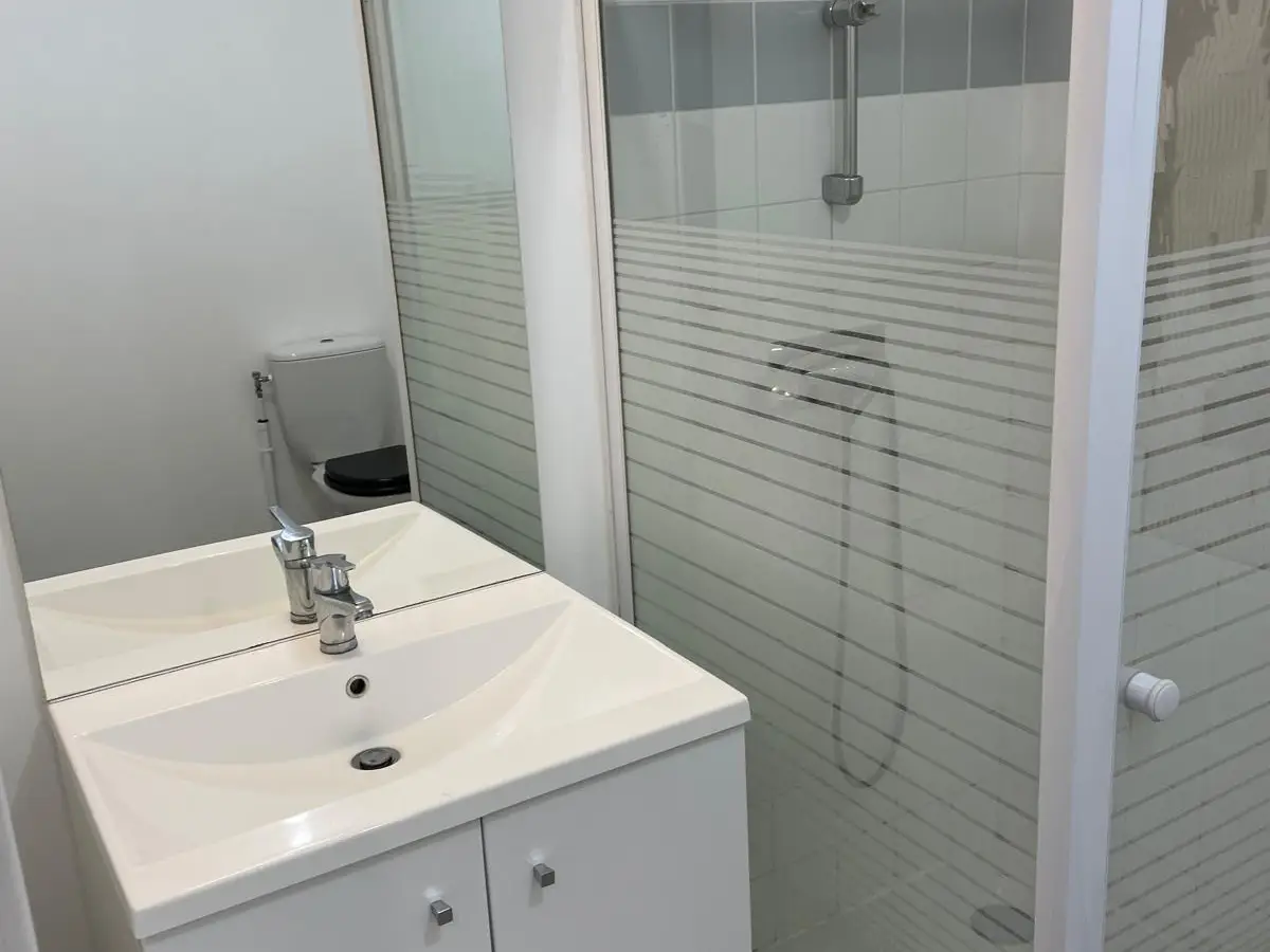 Salle d'eau avec douche et lavabo