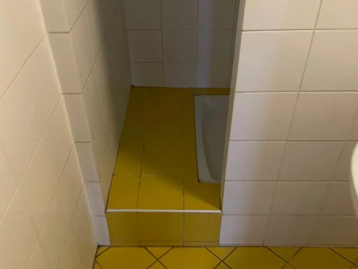 Cabine de douche carrelée au sol jaune
