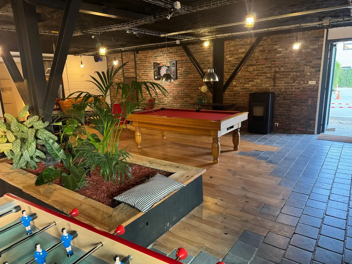 Salle commune avec billard et baby-foot, plantes