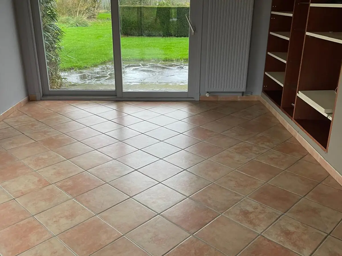 Pièce vide au carrelage terre cuite et baie coulissante