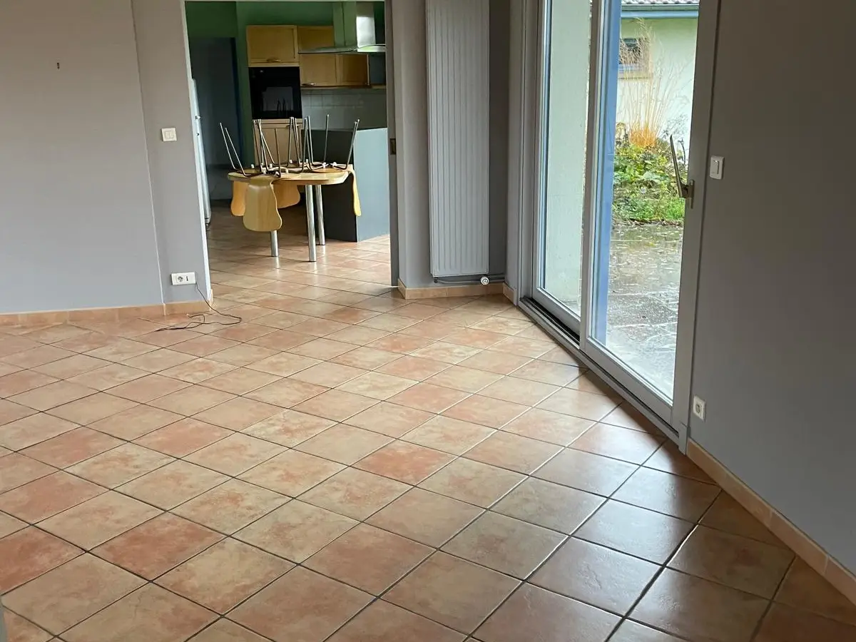 Salon vide avec carrelage terre cuite