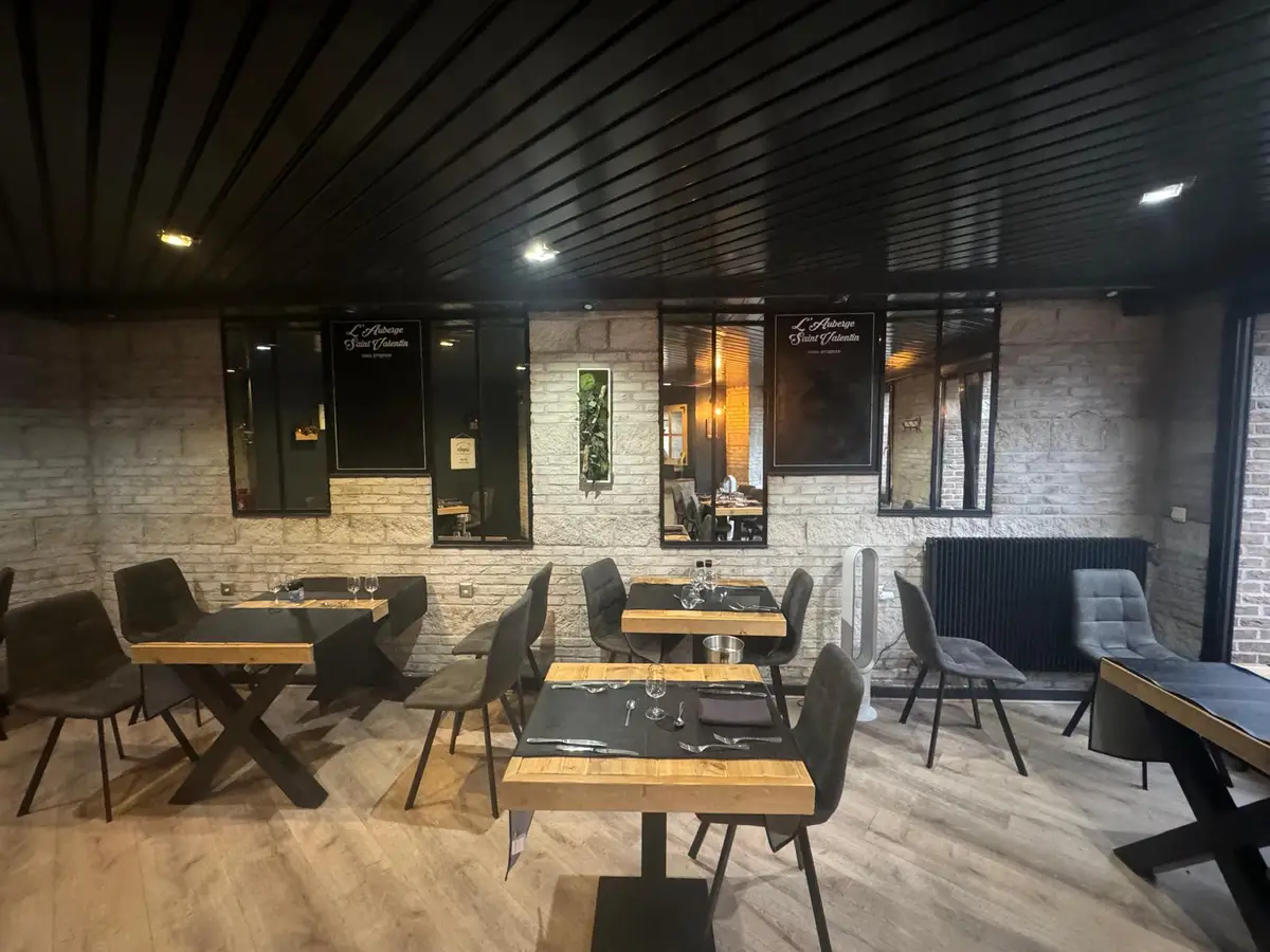 Salle de restaurant avec tables en bois et sol propre