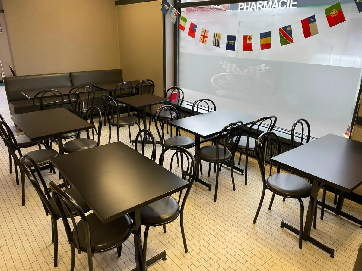 Salle de café avec tables noires et carrelage