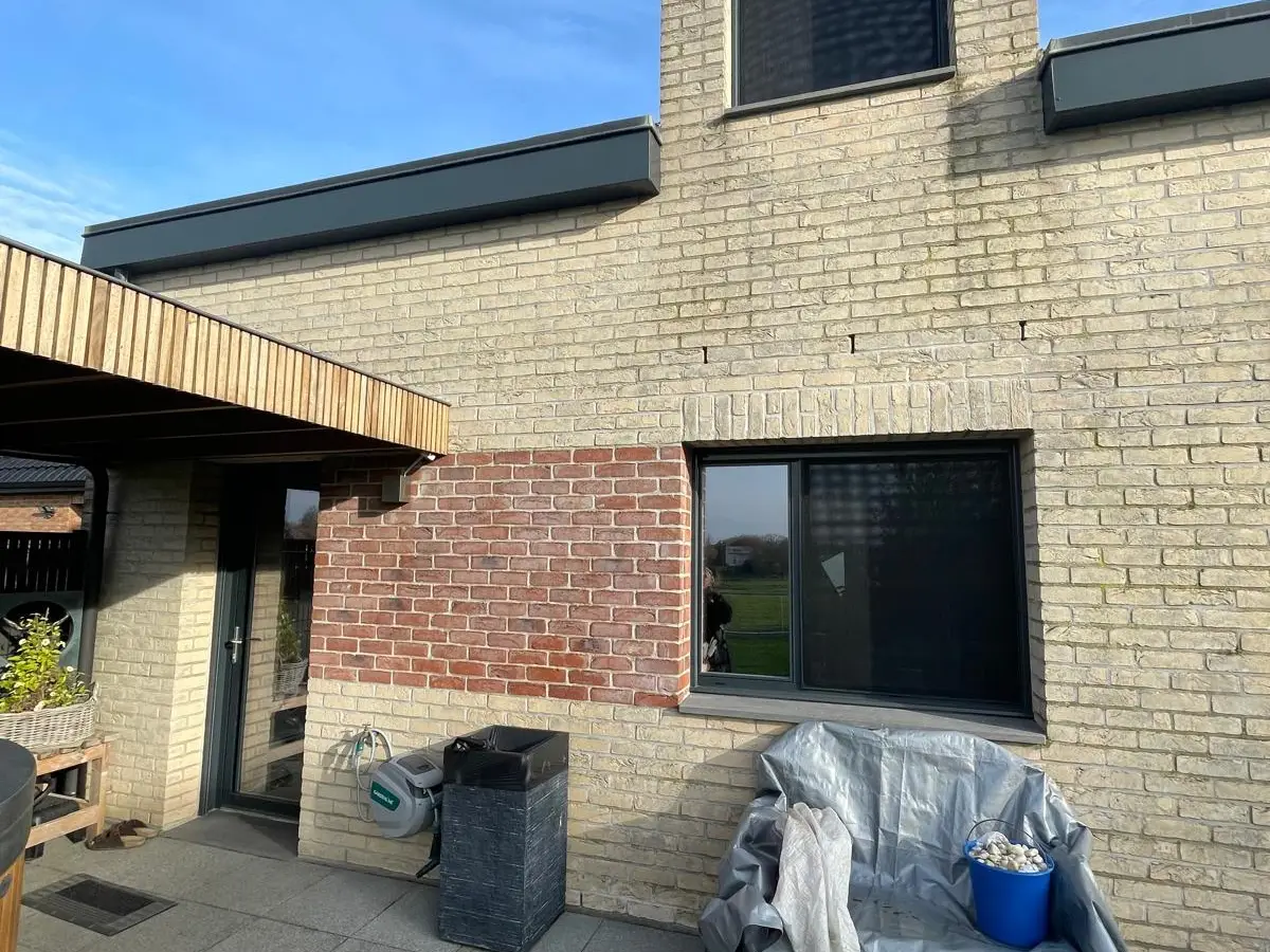 Terrasse en dalles contre une façade en briques