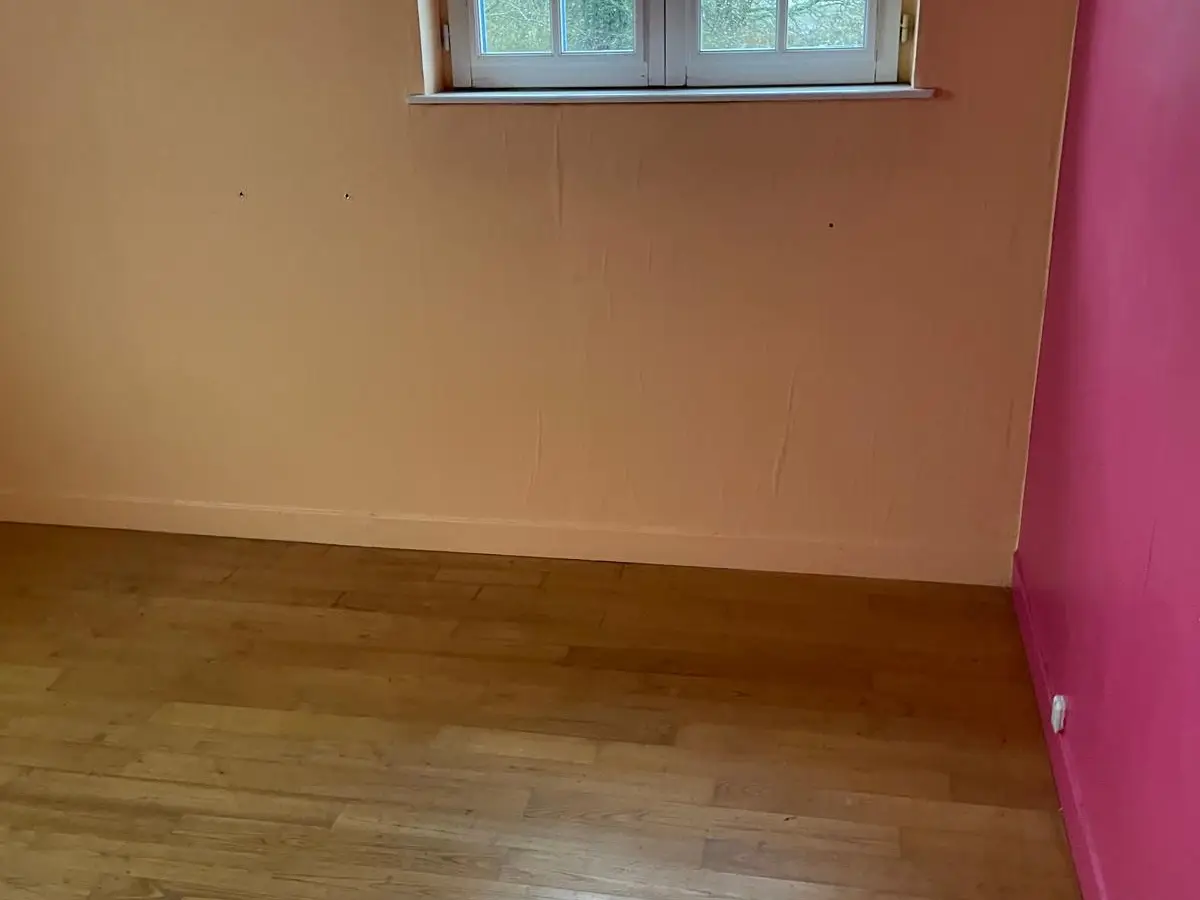Chambre vide, parquet et mur rose