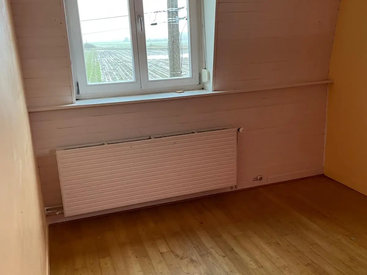Chambre mansardée vide au parquet