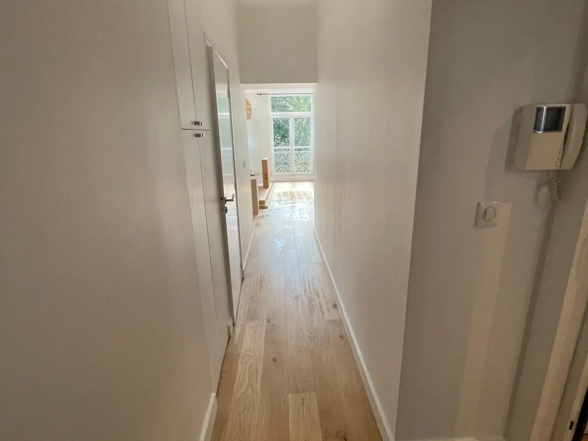 Couloir a parquet en chene et murs blancs apres nettoyage