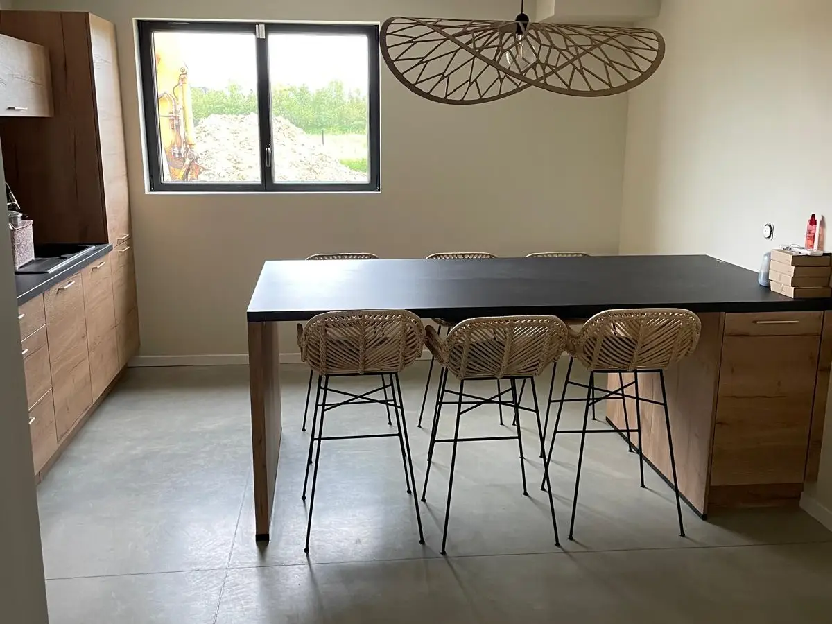 Cuisine neuve avec ilot et tabourets, sol en beton cire propre