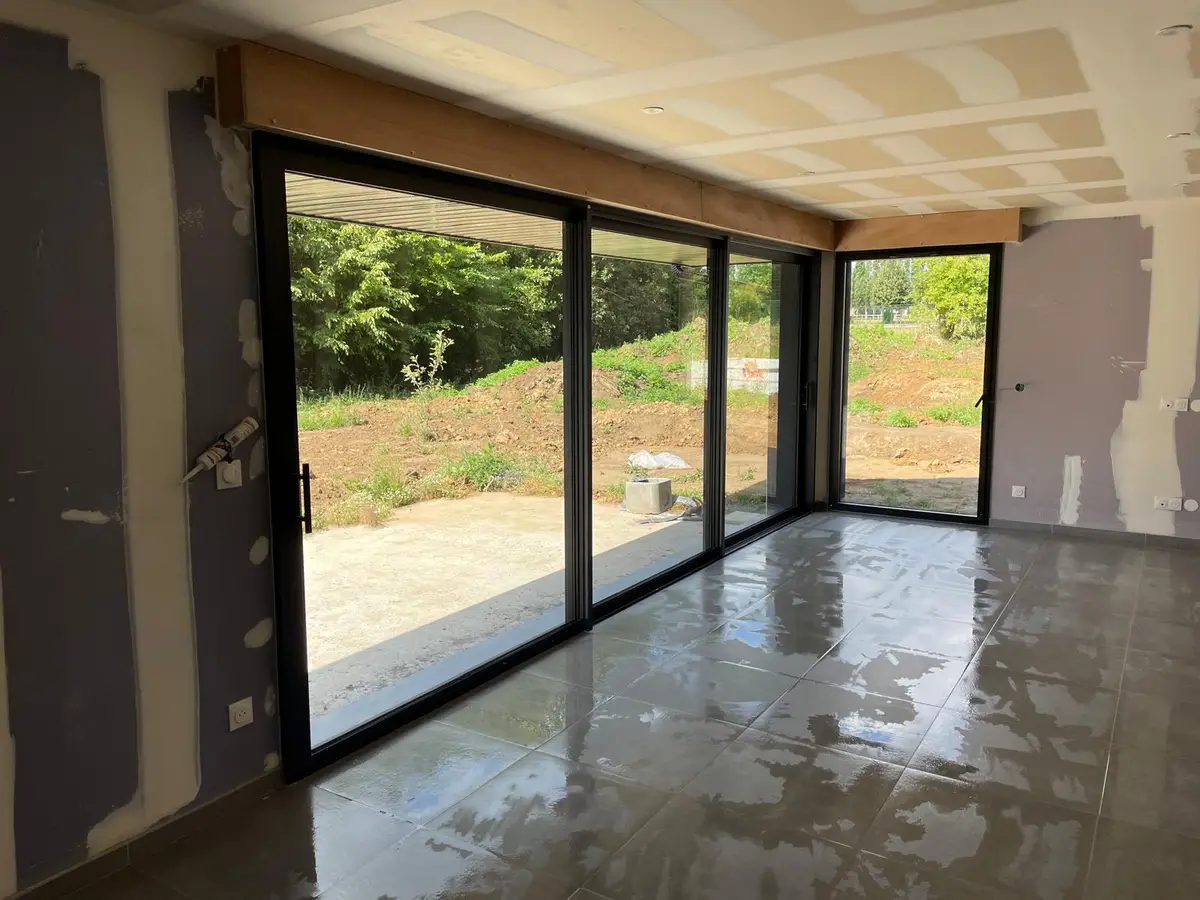 Piece en travaux avec grande baie vitree et carrelage lave