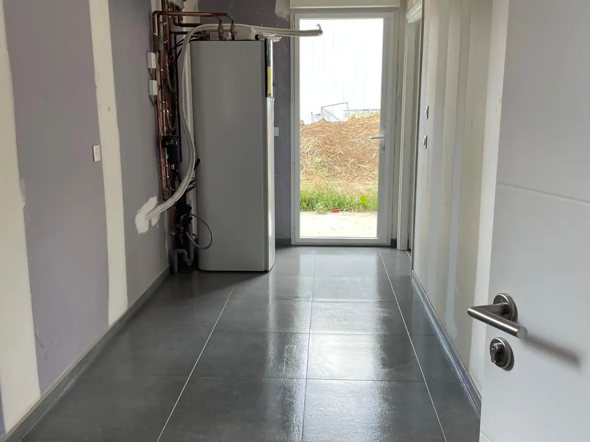 Couloir au carrelage gris neuf lave en fin de chantier