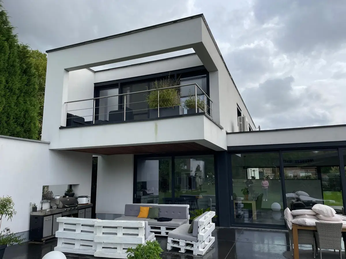 Facade de maison moderne avec grandes baies vitrees et terrasse