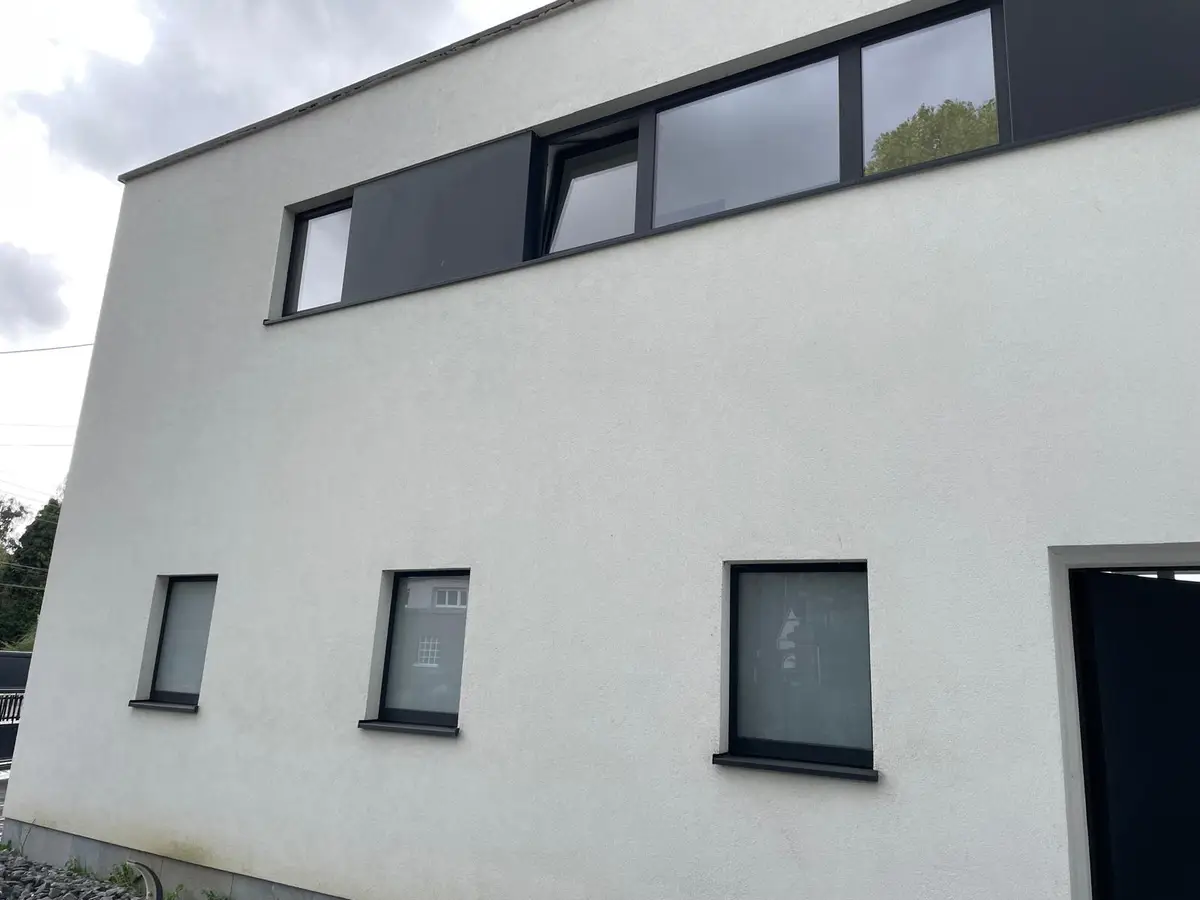 Facade blanche de maison moderne et ses fenetres