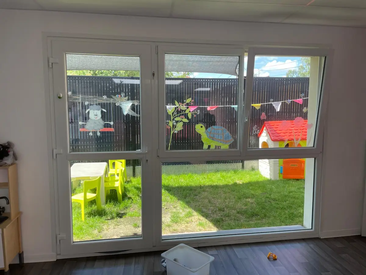 Grande baie vitree d'une creche avec decorations aux vitres, sans enfant