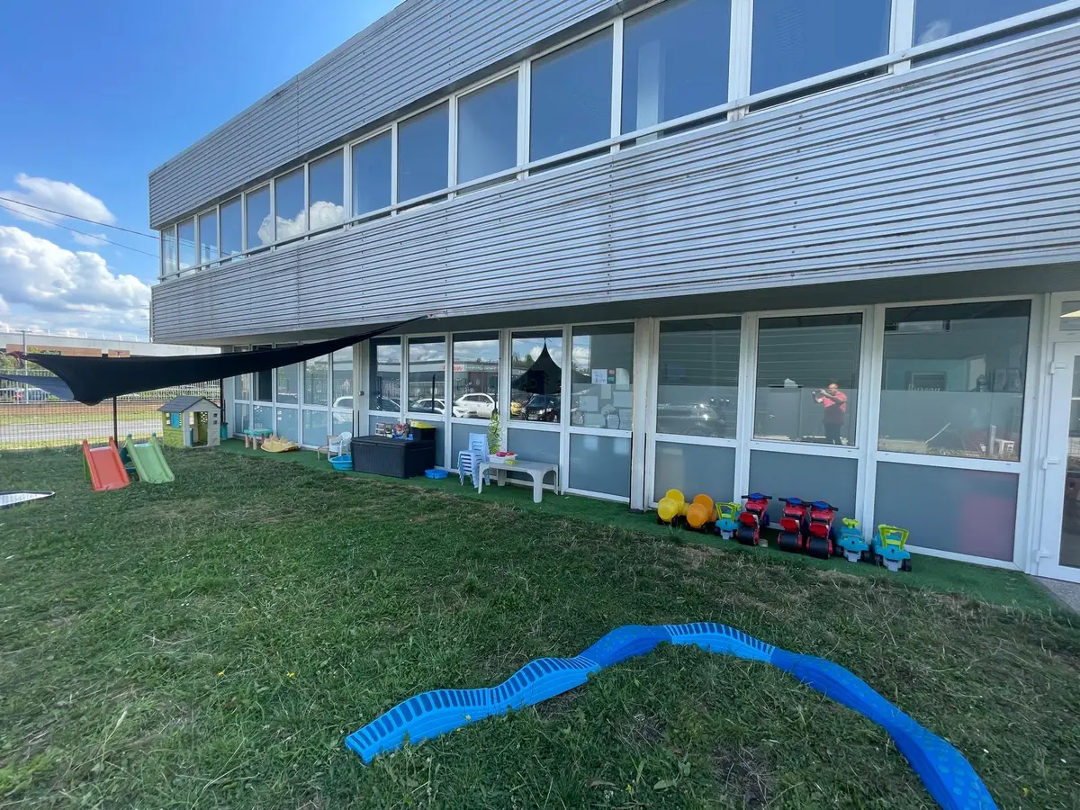 Facade vitree d'un batiment d'activites donnant sur la pelouse