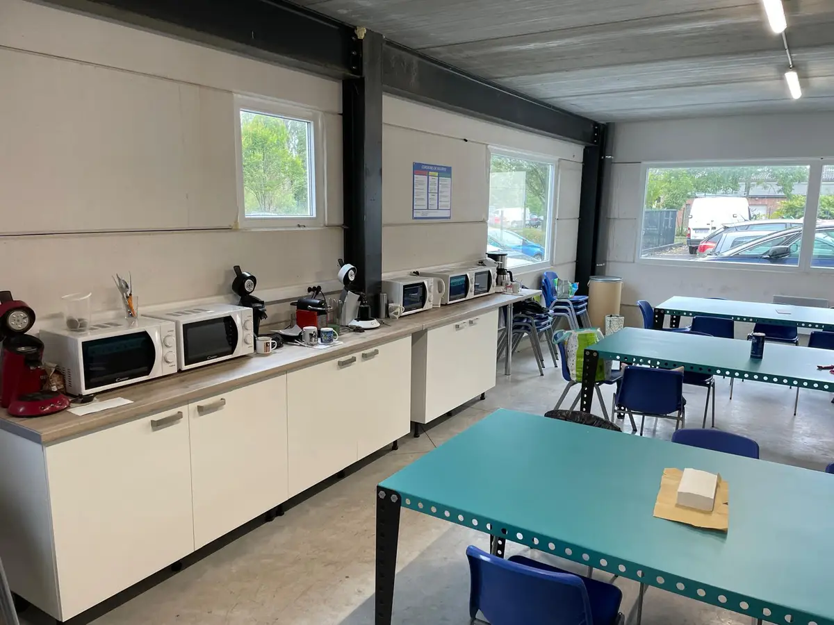 Salle de pause d'entreprise avec micro-ondes et tables
