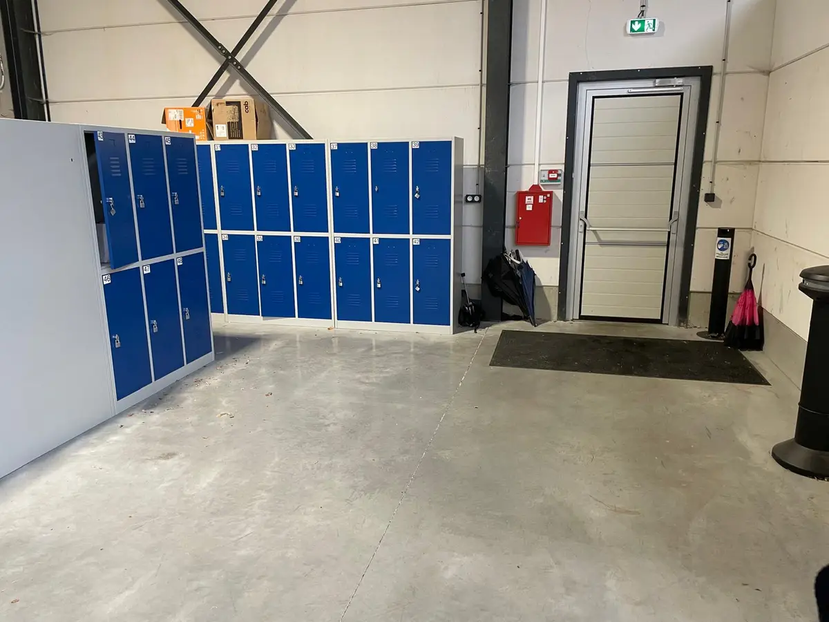 Vestiaires a casiers bleus et sol en beton