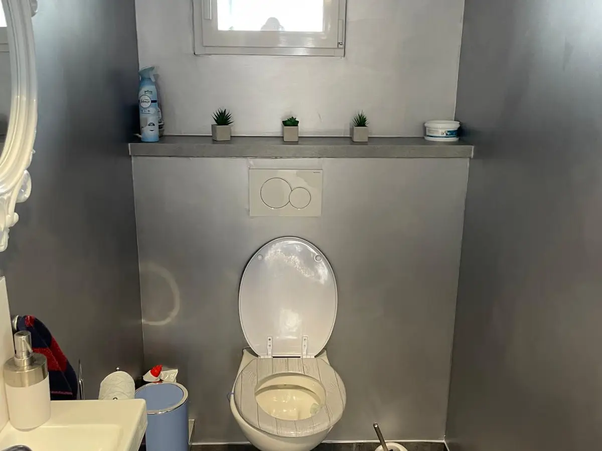 Toilettes d'entreprise aux murs gris avec lavabo