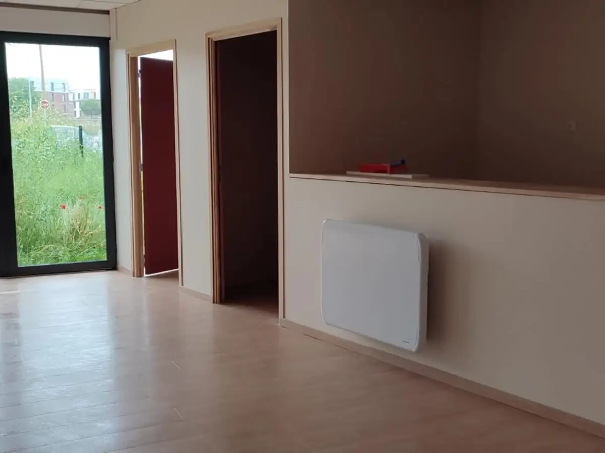 Bureau vide a parquet stratifie et grande baie vitree