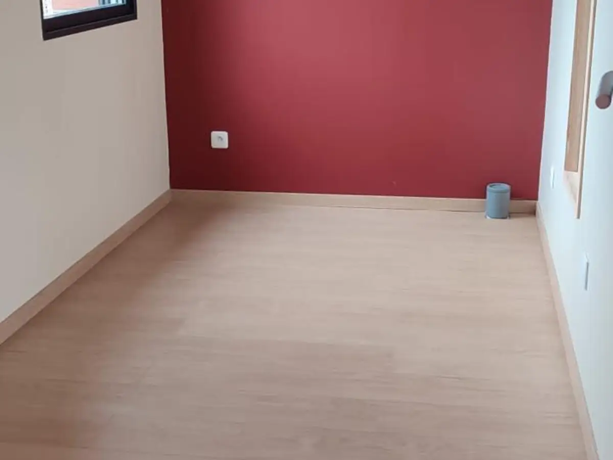 Bureau vide a parquet stratifie et mur bordeaux