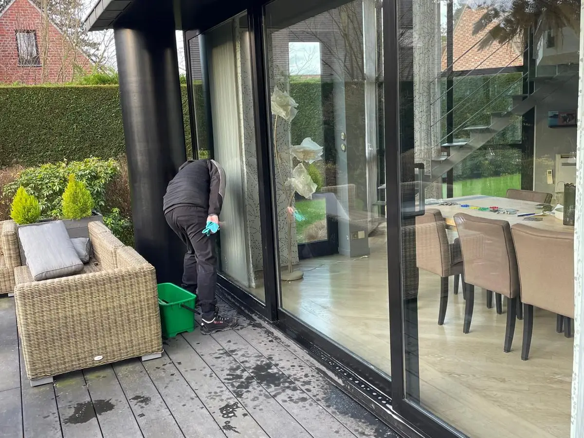 Nettoyage d'une grande baie vitrée coulissante sur terrasse en bois