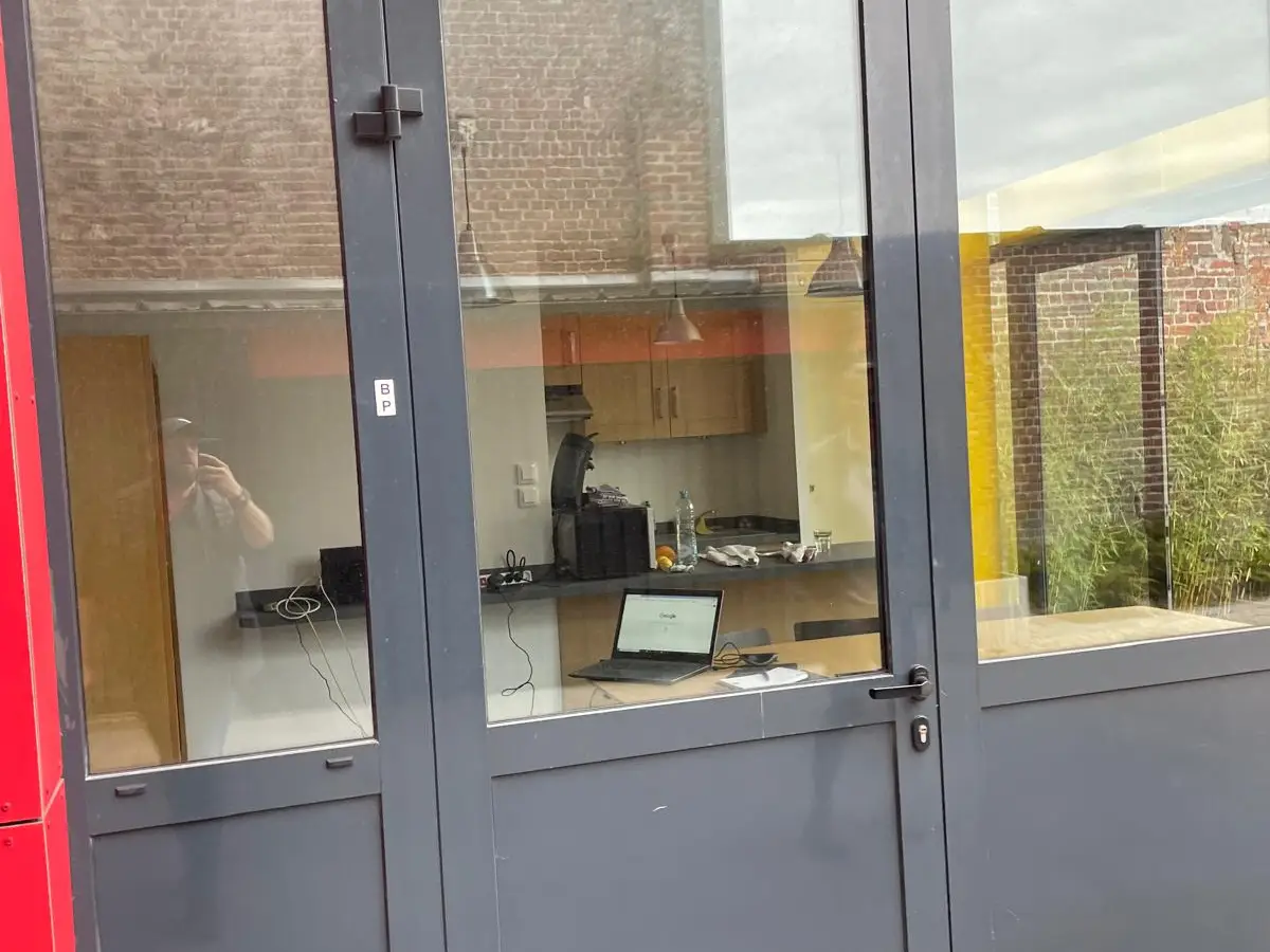 Porte et vitrage en aluminium dans une façade rouge et noire