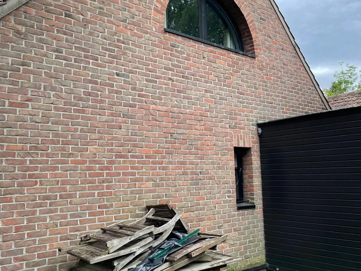 Maison en briques aux grandes baies vitrées noires, vitres propres