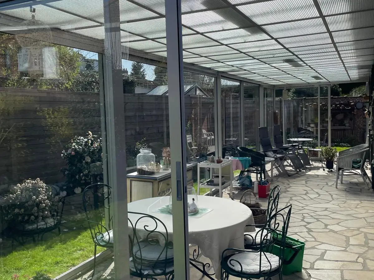 Véranda en aluminium aux vitres propres, table de jardin
