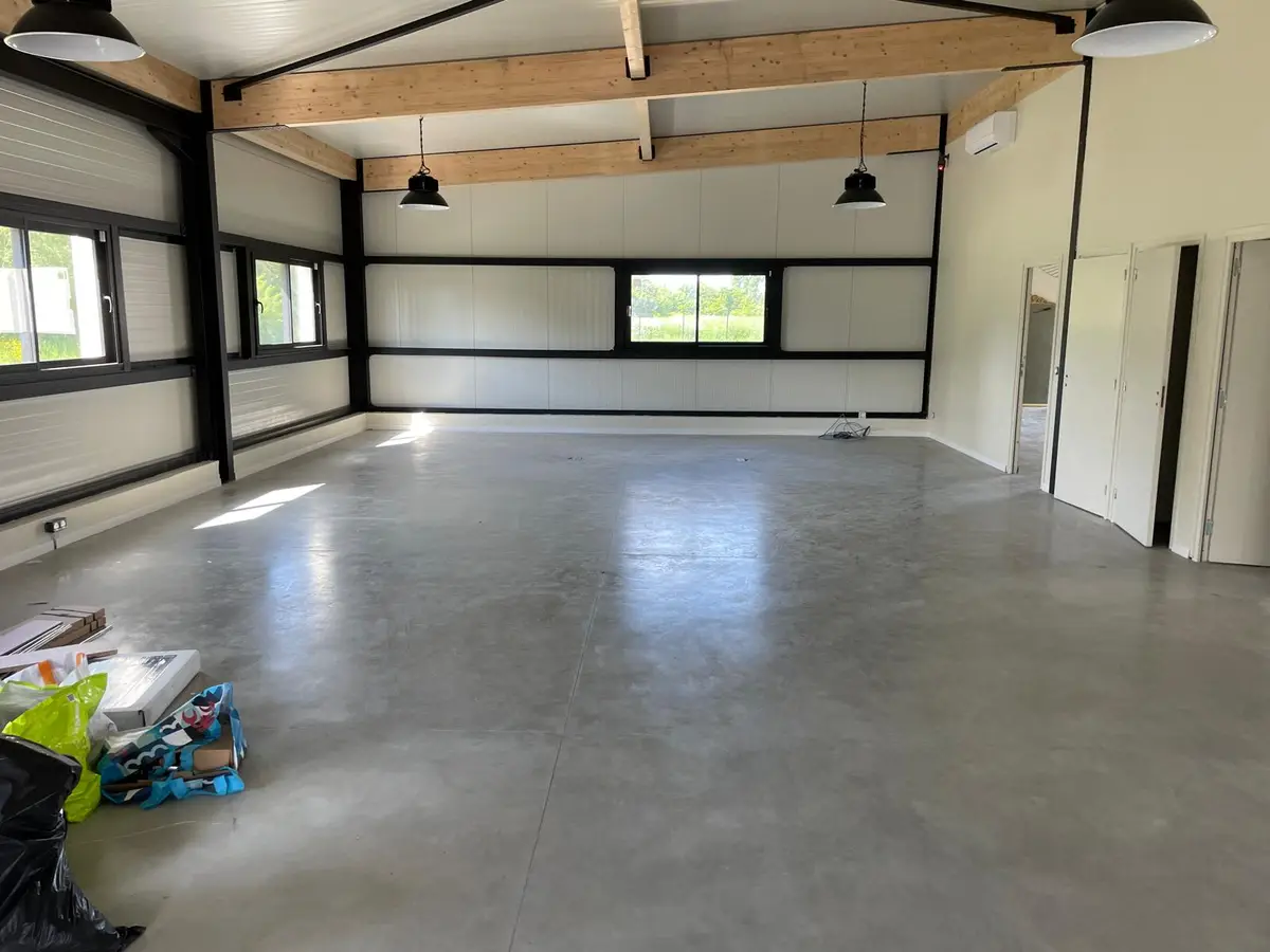 Espace neuf à sol béton ciré et poutres bois, nettoyé